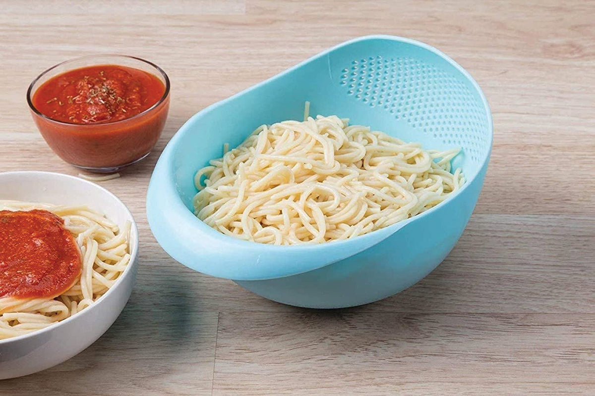 Large plastic rice bowl strainer in use, showing grains being washed.